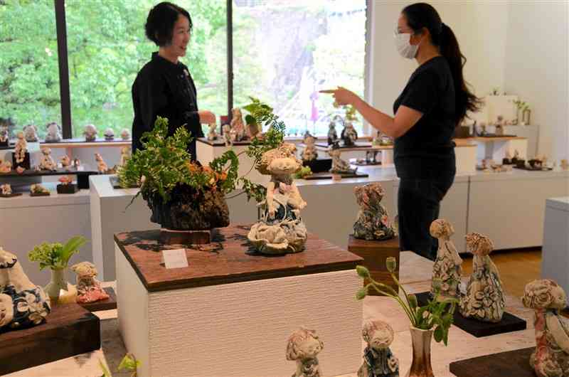 「共生」をテーマにした陶人形が並んだ西田美紀さん（左）の「土のカタチ展」＝28日、熊本市中央区