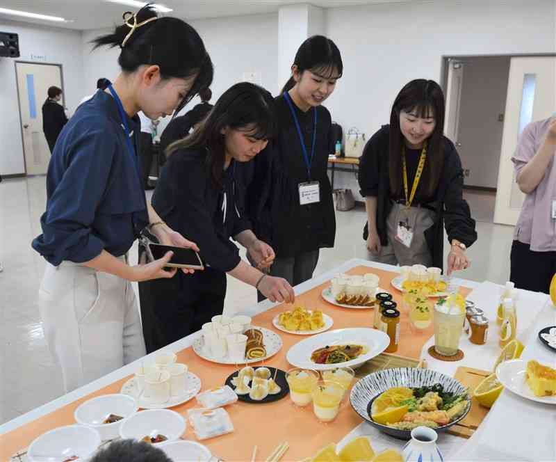 あまくさ晩柑を使ったスイーツや料理を試食する人たち＝28日、天草市