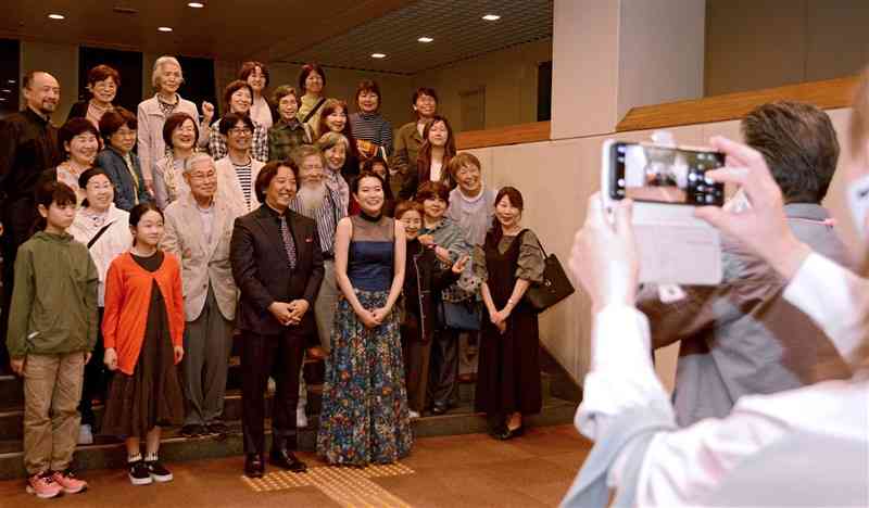 終演後、人吉労音の会員たちと記念写真に納まる辻彩奈さん（最前列の中央右）＝5月10日、人吉市カルチャーパレス