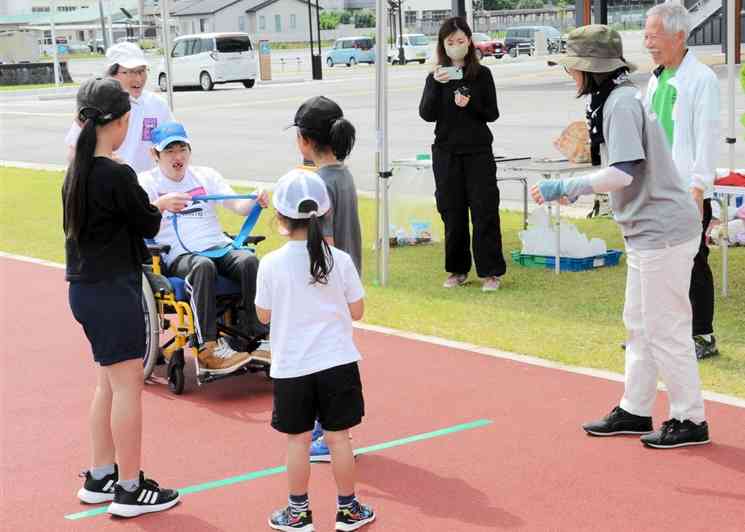 西原村で開催された「12時間リレーマラソン」で、中継地点でたすきを手渡す参加者たち＝2日