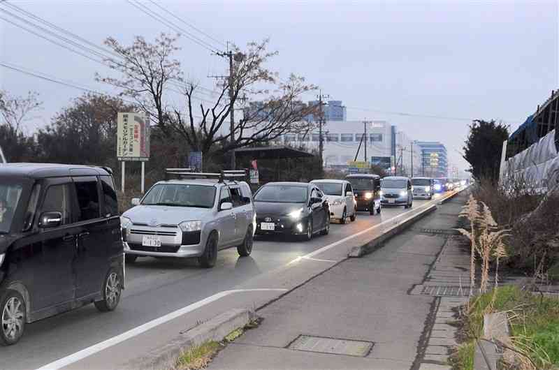 夕方に車が長い列を作る県道大津植木線。奥の建物はTSMCの工場＝1月31日、菊陽町