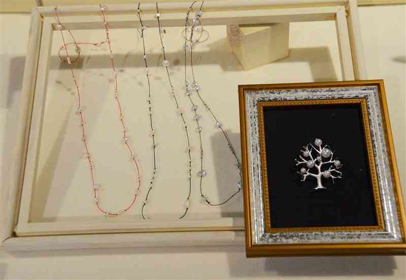 真珠専門店「NAP」が出品した淡水真珠のカジュアルなネックレスやシルバーの木に南洋真珠を飾り付けたブローチ＝4日、熊本市中央区