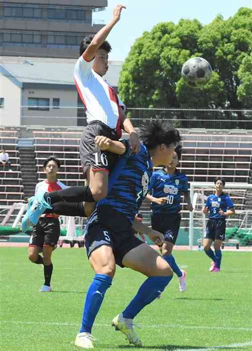 【サッカー男子準決勝・大津－熊本商】前半、ハイボールを競り合う熊本商のFW時田（左）と大津のDF五嶋（右）＝水前寺競技場