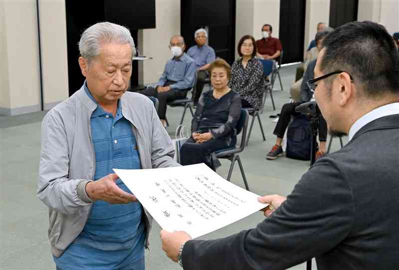 グランプリを受賞し、表彰を受ける松島一美さん（左）＝8日、熊本市中央区の熊日本社（小野宏明）