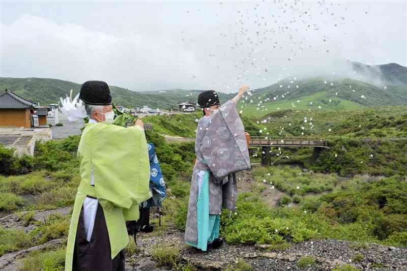 火口に向かって火山活動の沈静化を祈る神職＝10日、阿蘇市