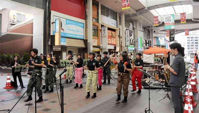 演奏に合わせてダンスをする熊本農高吹奏楽部の生徒ら＝15日、熊本市中央区