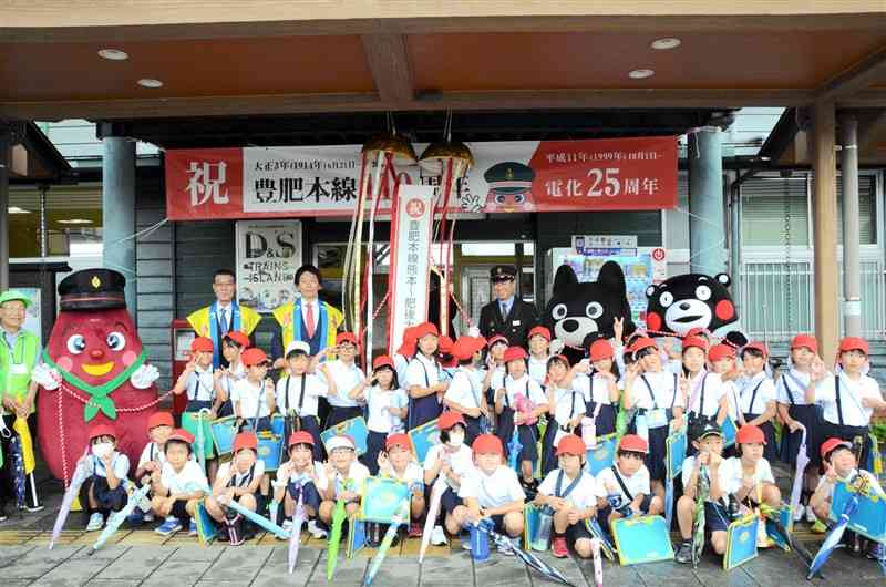 JR豊肥線の熊本－肥後大津間の開業110周年を祝う地元児童や関係者ら＝21日、大津町