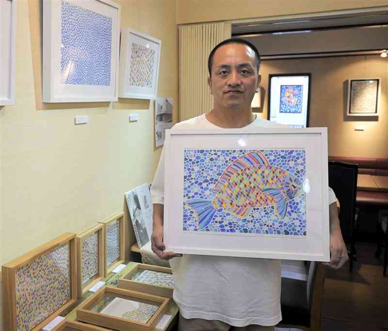 切り絵を中心に作品を展示している庄村紀彦さん＝22日、荒尾市