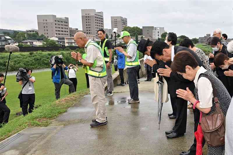 6・26水害慰霊祭の法要後、白川に向かって合掌し犠牲者に祈りを捧げる住民ら＝26日午前、熊本市中央区の白川河川敷（上杉勇太）