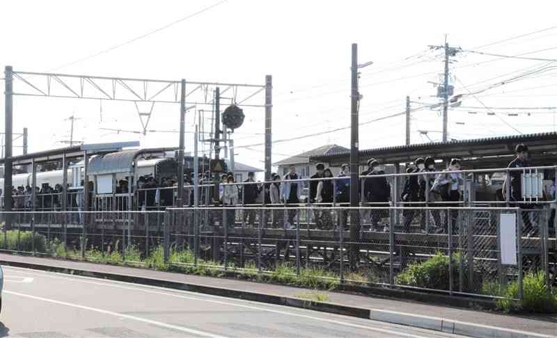 JR原水駅のホームからバス乗り場へ向かう通勤客＝4月、菊陽町