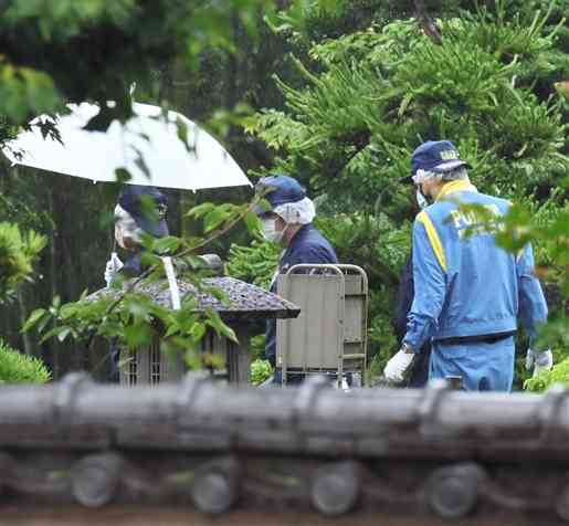 中村尊徳さんが殺害されて見つかった自宅敷地内を調べる熊本県警の捜査員＝2021年5月24日、熊本市南区城南町