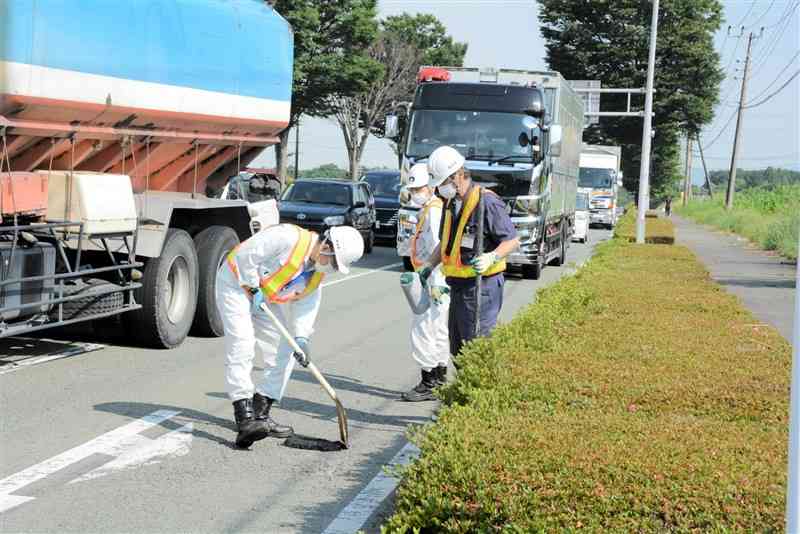 道路パトロール中に見つけた路面の小さな穴をふさぐ職員＝6月中旬、大津町