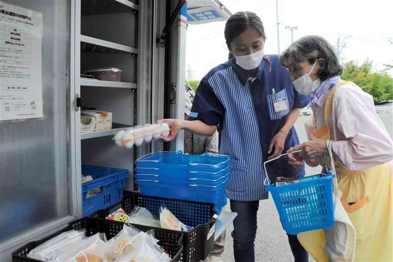 利用者の要望を聞きながら商品を案内する販売員の田中美穂子さん（左）＝６月19日、熊本市西区