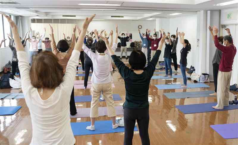 認知症予防に効果があるとされる運動をする参加者＝2021年5月、神奈川県内