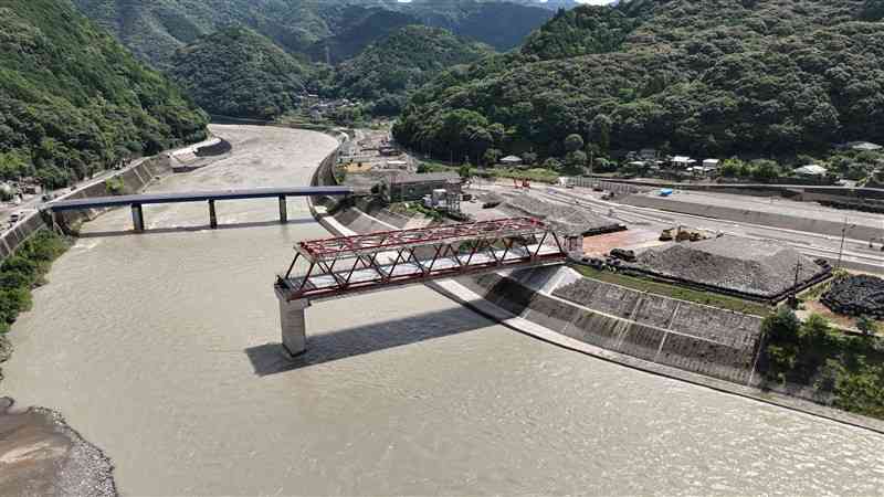 球磨川で架橋工事が進められている坂本橋（中央の赤い橋）。右岸ではかさ上げ工事も進んでいた＝3日、八代市坂本町（ドローン撮影、谷川剛）