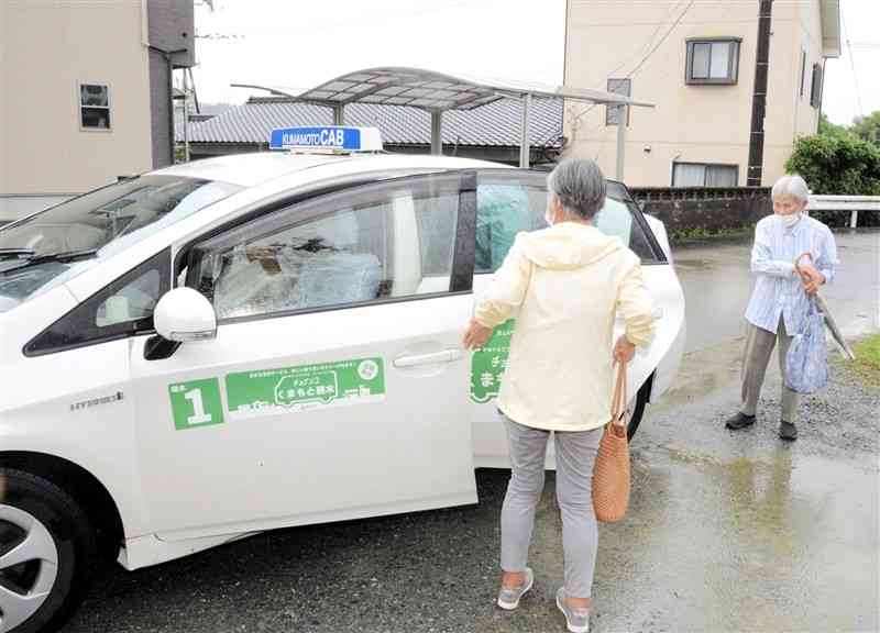 公民館に設置された停留所で「チョイソコくまもと」から降りる乗客ら＝6月27日、熊本市北区