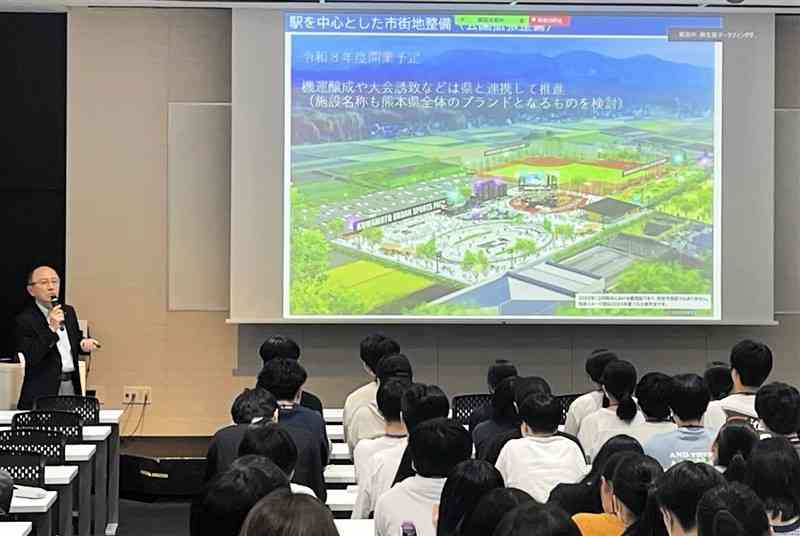 学生たちに菊陽町のまちづくりについて講演する小牧裕明副町長（左奥）＝1日、福岡市