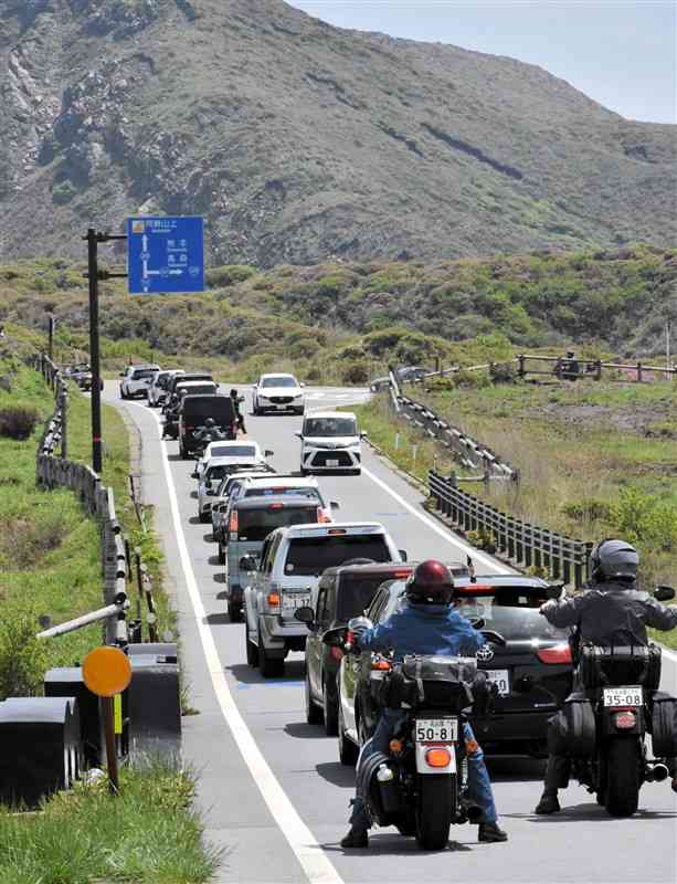 阿蘇山上広場と中岳火口の見学エリアへ向かって連なる車やオートバイの列＝5月、阿蘇市