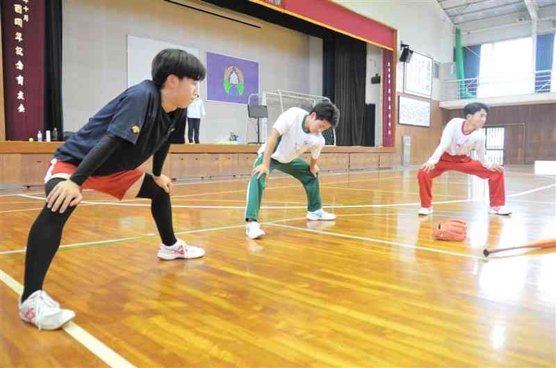 降雨のため、体育館でストレッチをする矢部高のメンバー。全国高校野球選手権熊本大会には6校の連合チームで出場する＝6月24日、山都町（河北英之）