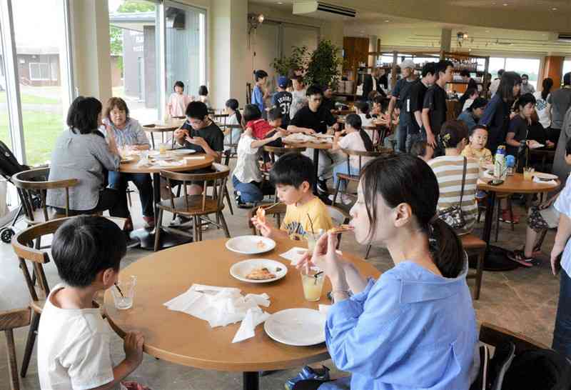 焼きたてのピザを味わう子どもたちと保護者ら＝7日、産山村