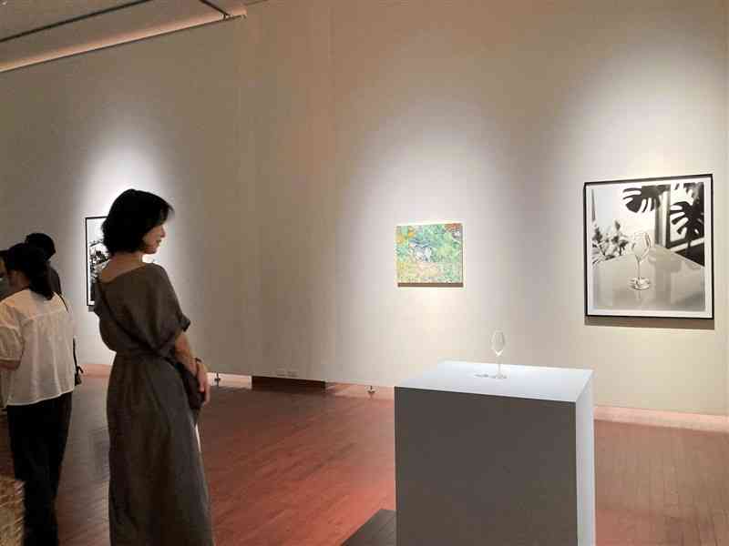 グラスとそれをモチーフに描いた絵画や写真などが並ぶ「ガラスの器と静物画」の会場＝12日、熊本市中央区