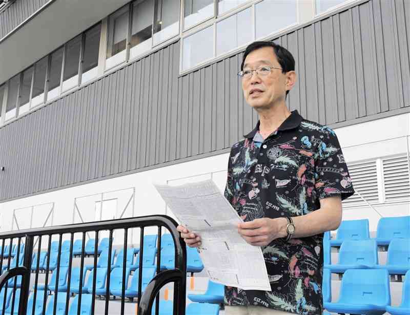 自ら執筆した予想紙を手に、競輪の魅力を語る「コンドル出版」の武田幸三さん。熊本競輪場のレース再開を心待ちにしている＝14日、熊本市中央区