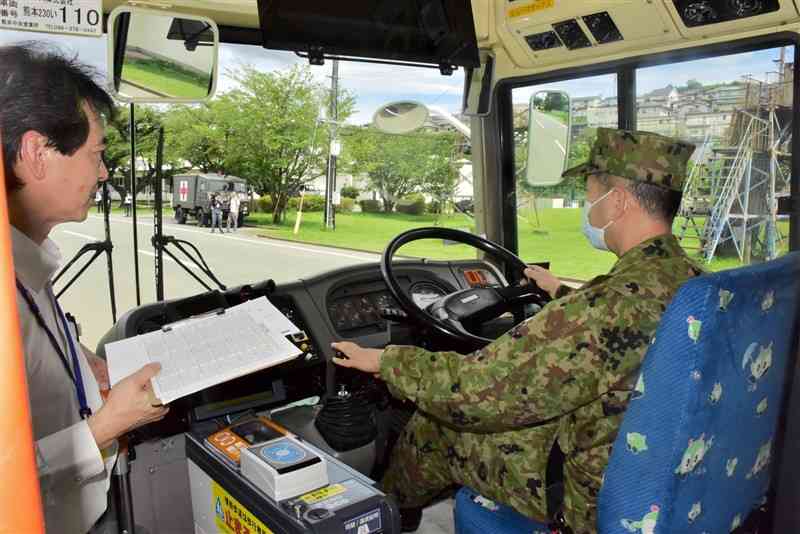 陸上自衛隊北熊本駐屯地内で路線バスの運転を体験する自衛官＝18日、熊本市北区