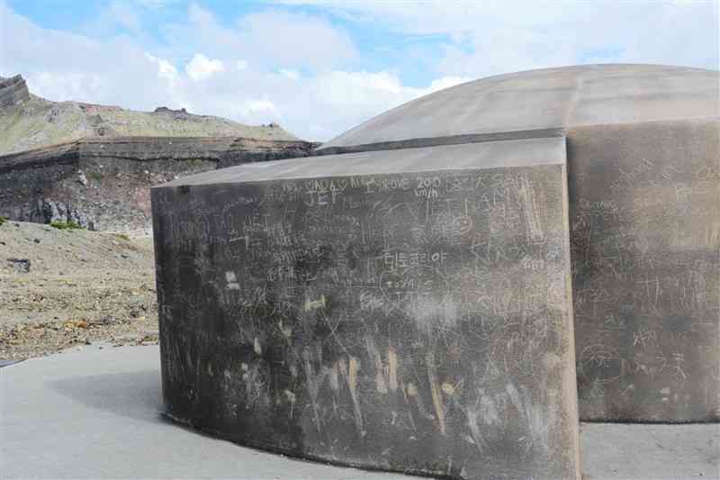 ローマ字や漢字、ハングルや平仮名などさまざまな文字で描かれた退避壕の落書き＝19日、阿蘇市