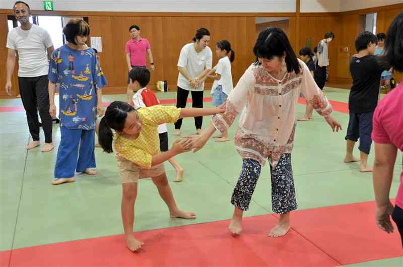 習った護身術を実践する親子ら＝20日、熊本市中央区