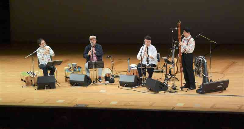 さまざまな楽器で演奏を披露する「栗コーダーカルテット」＝20日、熊本市中央区
