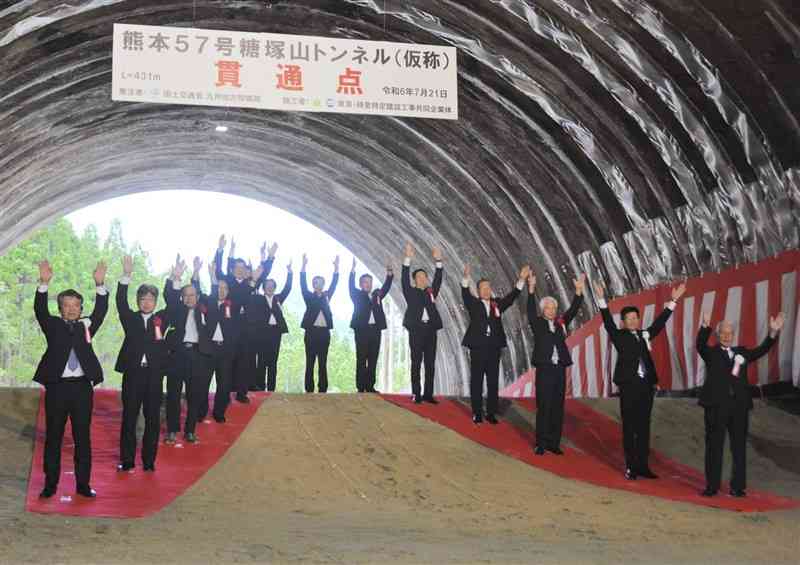 宇土道路の糖塚山トンネルの貫通を迎え、万歳をする式典参加者ら＝21日、宇土市