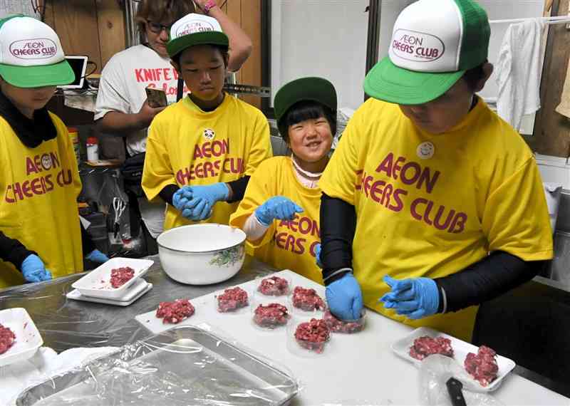 イノシシとシカの合いびき肉で作ったパティの形を整える小学生＝23日、多良木町