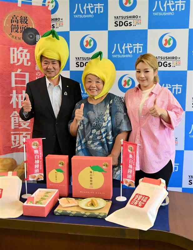 晩白柚饅頭を開発したユニックスの岩橋香代子専務（中央）。左は中村博生八代市長＝23日、同市
