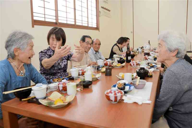 同窓会で小中学生時代の思い出話に花を咲かせる早川ハルヨさん（左から2人目）＝７月24日、熊本市北区