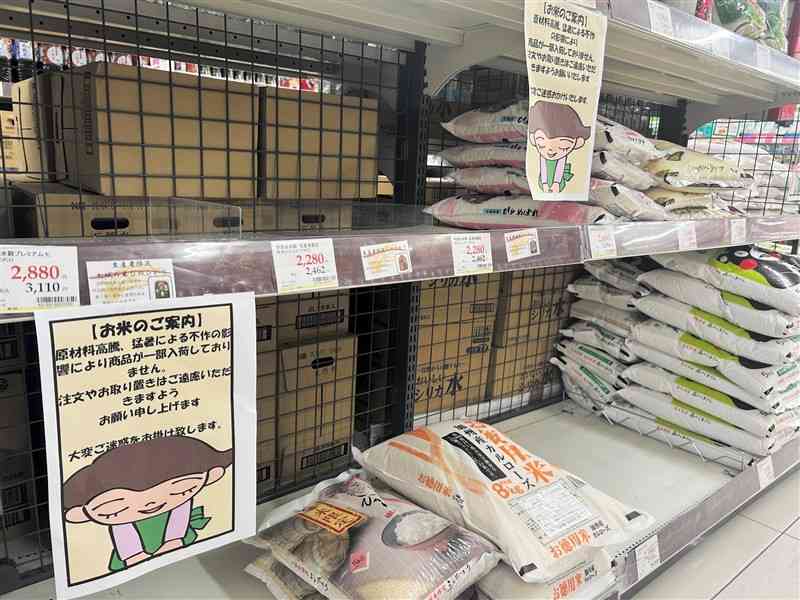 一部銘柄が入荷していないスーパーの米売り場。注文や取り置きを控えるよう呼びかける「ご案内」を掲示している＝26日、熊本市中央区