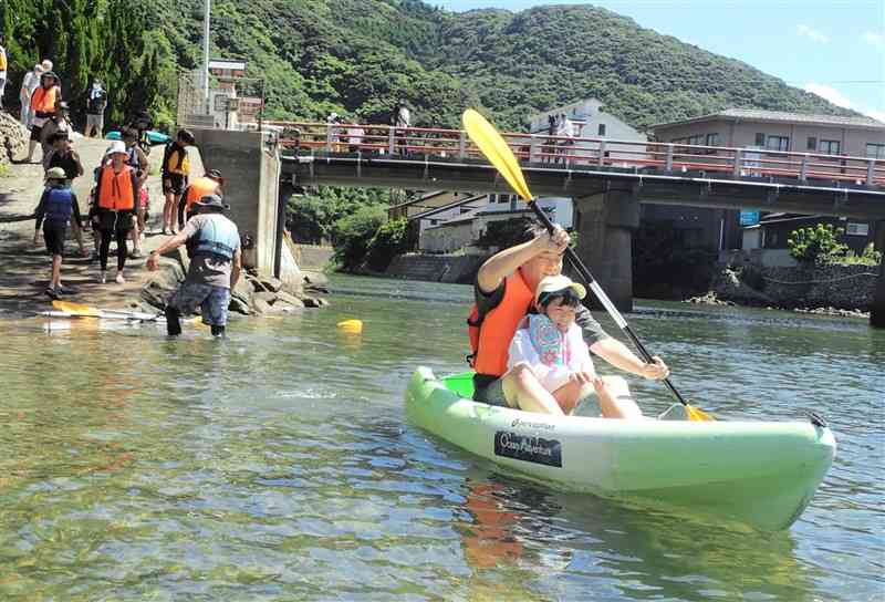 下田温泉街を流れる下津深江川でシーカヤックを楽しむ参加者＝７月27日、天草市