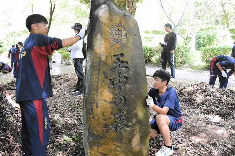 「玉中の森」の石碑を磨く玉名中の生徒＝7月29日、玉名市