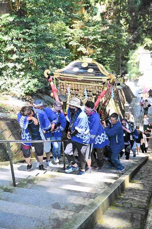 草部吉見神社の夏季大祭で、汗を拭いながら石段を上る氏子ら＝7月31日、高森町
