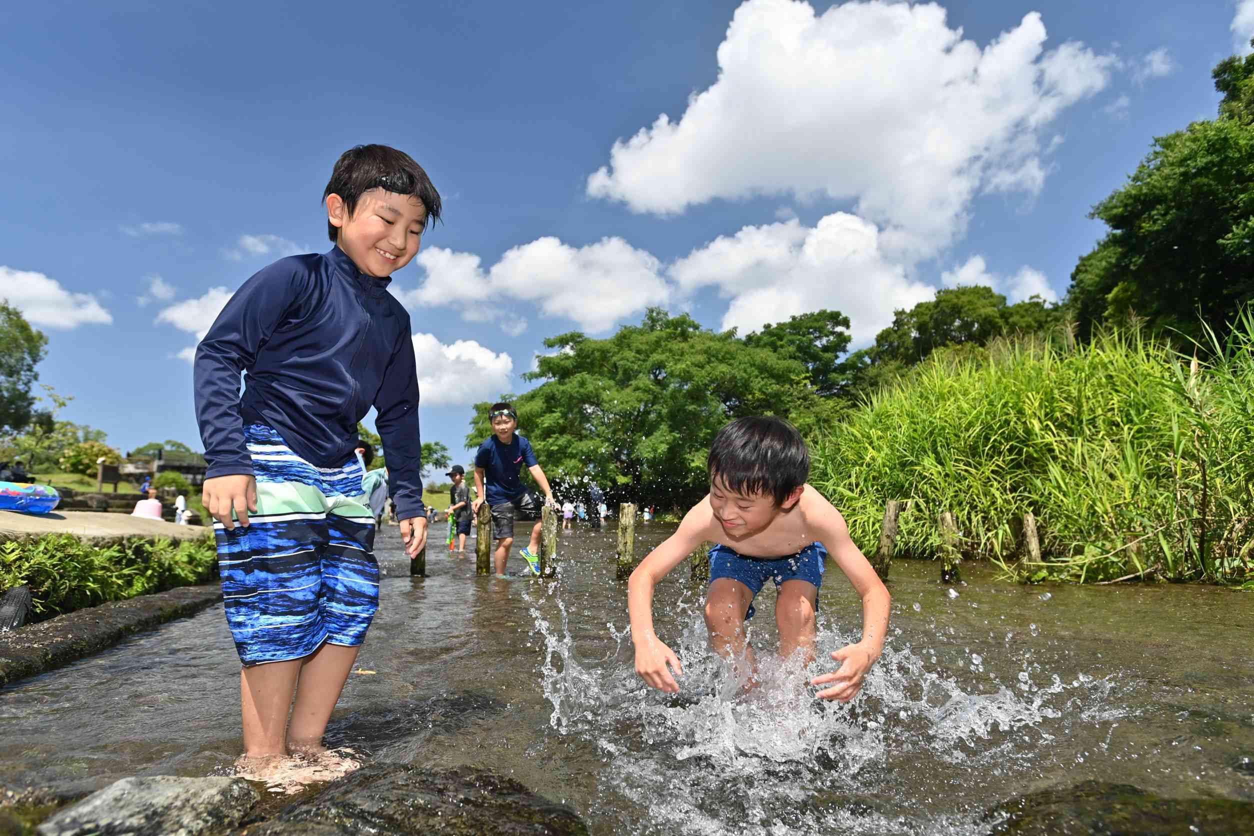 江津湖の浅瀬で水遊びする子どもたち＝22日午前、熊本市中央区（上杉勇太）