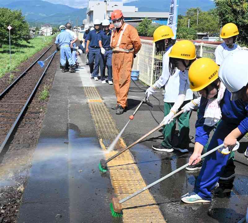 多良木駅の汚れた点字ブロックをきれいに清掃する高校生＝7月29日、多良木町