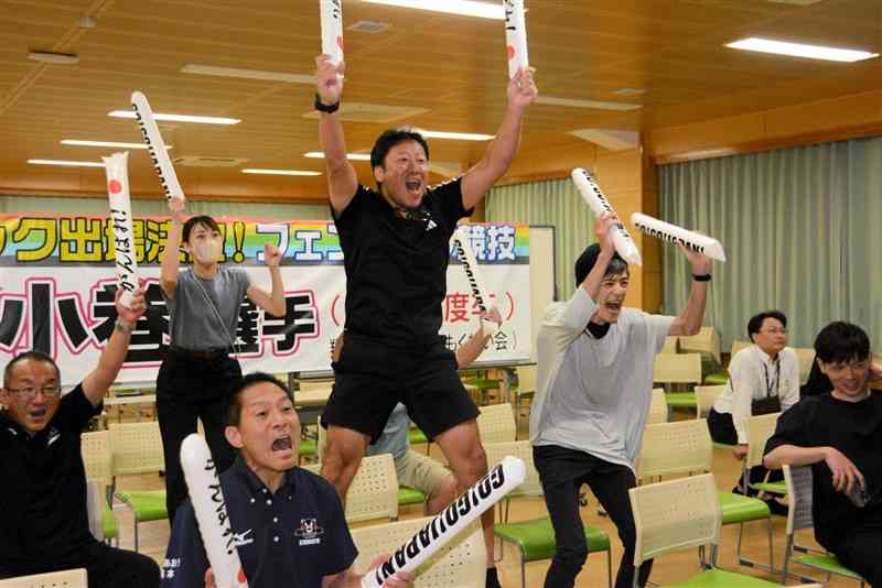 パリ五輪のフェンシング女子フルーレ団体で日本代表が銅メダルを決め、跳び上がって喜ぶ翔陽高フェンシング部の太田健二監督（中央）ら＝2日未明、大津町
