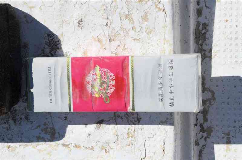 船崎和生さんが海上で回収したたばこ。中国語とみられる文字がある＝7月末、天草市