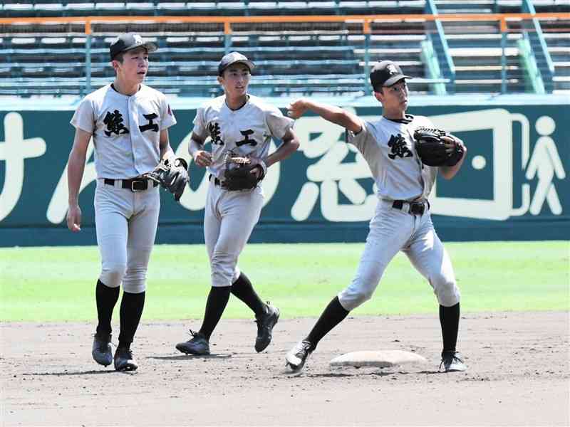 ノックを受ける熊本工の浦上雄宇遊撃手（右）ら＝甲子園球場