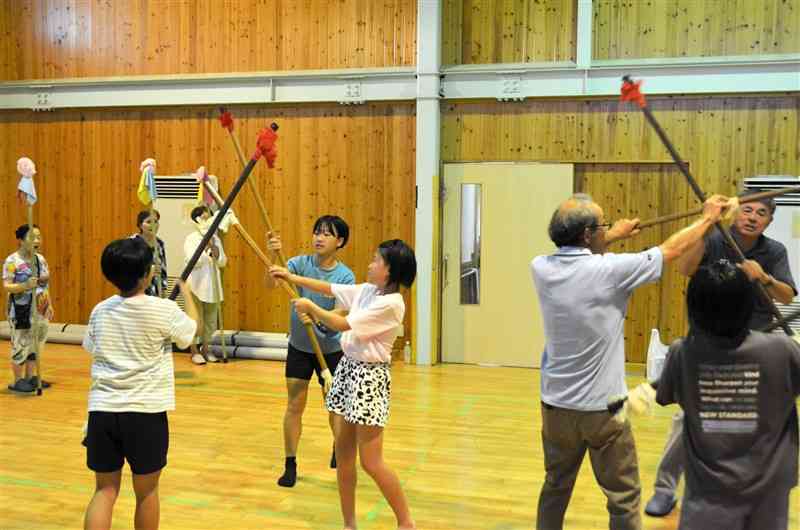 「くまもと子ども芸術祭2024inうと」に向けて、「宇土松山の花棒踊り」を練習する花園小6年生と保存会のメンバー＝7月27日、宇土市