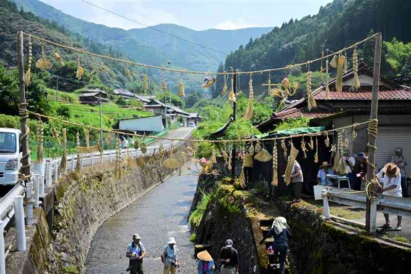 中谷川の上に七夕綱を張る木々子地区の住民ら＝6日、八代市坂本町