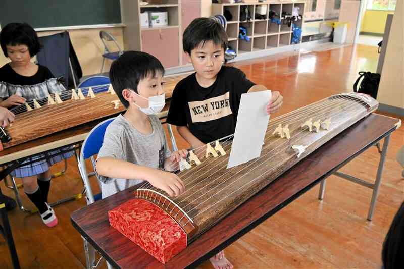 夢中になって琴を弾く児童ら＝6日、南阿蘇村