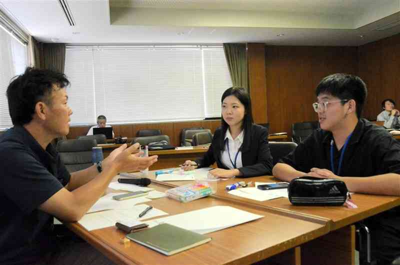 インターンシップの1カ月間を振り返り、今後の目標を話し合う台湾の大学生と企業担当者（左）＝6日、熊本市中央区