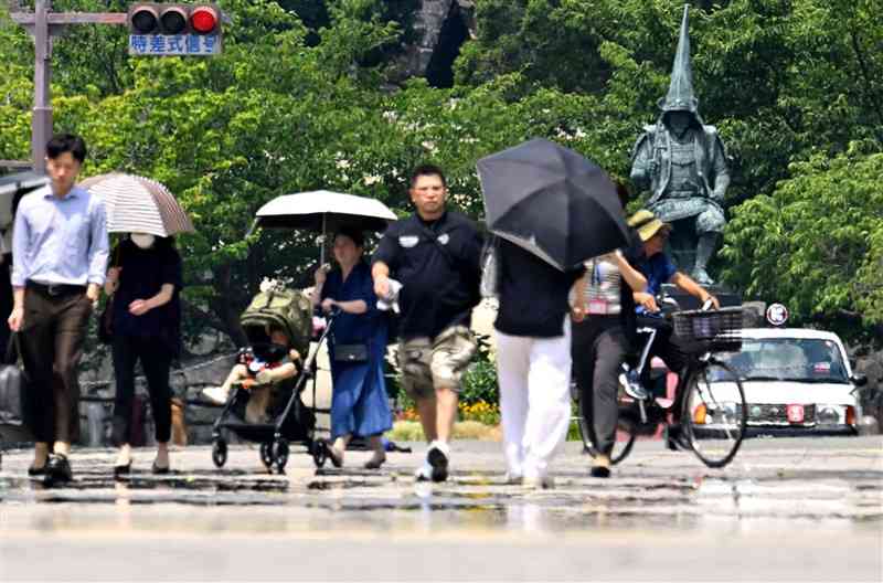 連日猛暑日を記録する熊本市。中央区の花畑広場から加藤清正像を望むと、遠くに水があるように見える「逃げ水現象」が見られた＝7日午後1時過ぎ（上杉勇太）