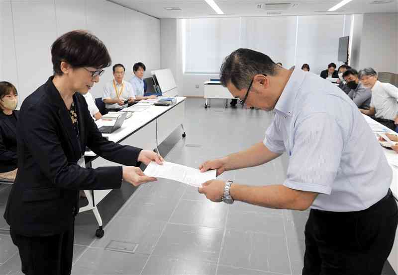 私立高への助成拡充の要請書を県私学振興課の松村加奈子課長（左）に手渡す「熊本私学助成をすすめる会」の竹原一輝代表＝7日、熊本県庁