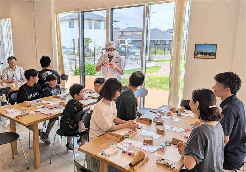 大型分譲地の集会所で開かれた日本と台湾の交流イベント。住民らが和菓子作りを通じて親睦を深めた＝4日、合志市